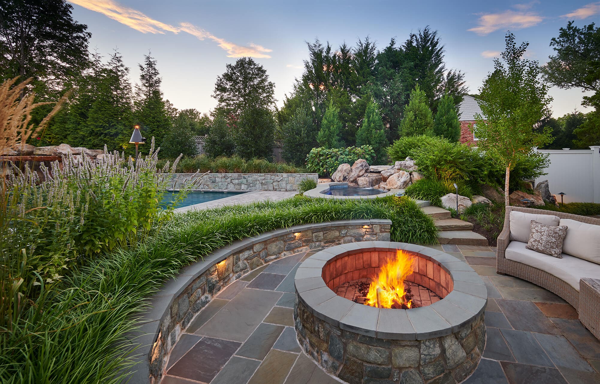 Landscape designers reviewing garden plans beside a thoughtfully arranged outdoor space